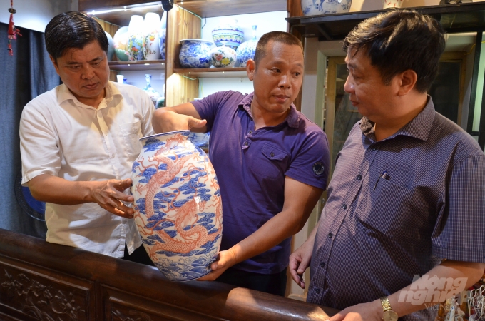 Thứ trưởng Trần Thanh Nam (áo trắng) đang xem một sản phẩm gốm thấu quang độc đáo. Ảnh: Dương Đình Tường.