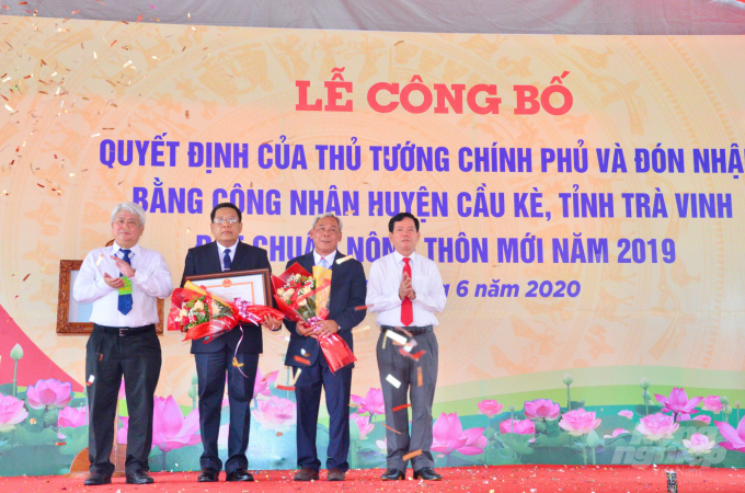 Lãnh đạo huyện Cầu Kè đón bằng công nhận huyện đạt chuẩn nông thôn mới của Thủ tướng Chính phủ. Ảnh: Minh Đảm.