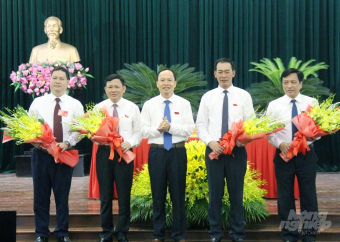Ông Nguyễn Văn Thi (thứ 2 từ trái sang) nhận hoa chúc mừng của ông Trịnh Văn Chiến, Bí thư Tỉnh ủy, Chủ tịch HĐND tỉnh Thanh Hóa. Ảnh: Võ Dũng.