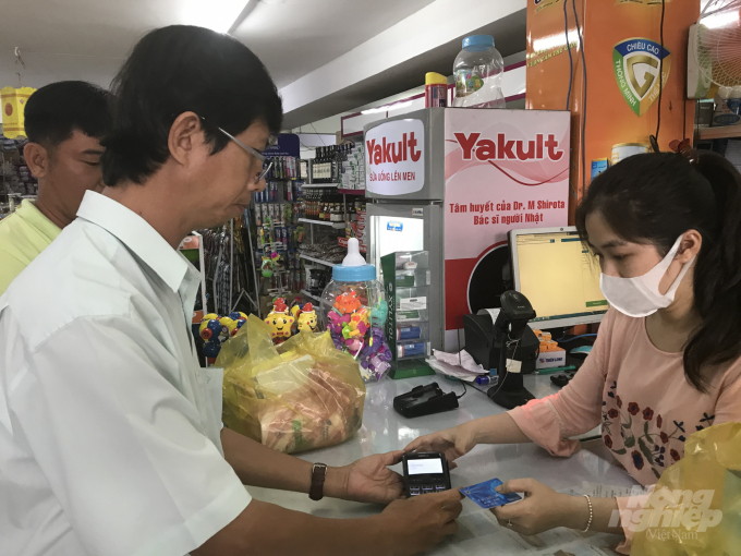 Khách hàng thanh toán bằng thẻ thấu chi của Agribank tại cửa hàng Bình An, thị trấn Hậu Nghĩa. Ảnh: Thanh Sơn.