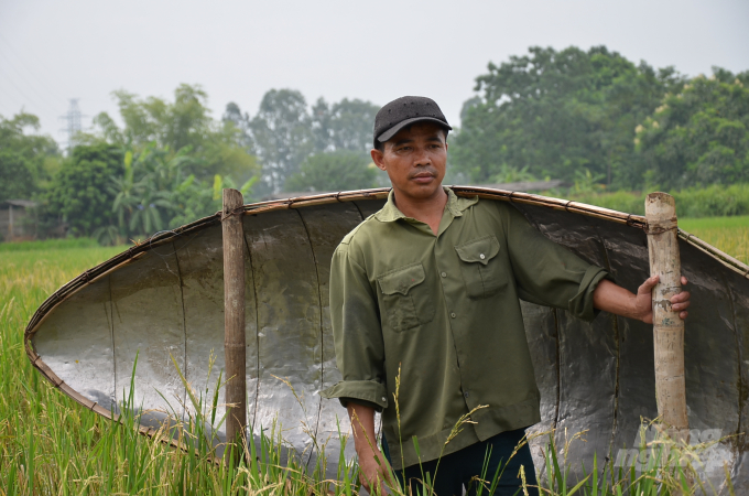 Một nông dân vác thuyền qua thửa ruộng hoang mọc toàn lúa chét ở Vĩnh Phúc. Ảnh: Dương Đình Tường.