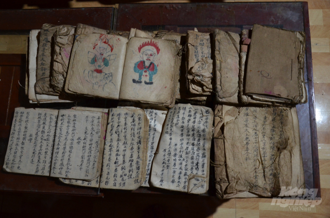 Đống sách cổ của ông Pu có cả chữ nho lẫn các hình vẽ khi cúng tế. Ảnh: Dương Đình Tường.