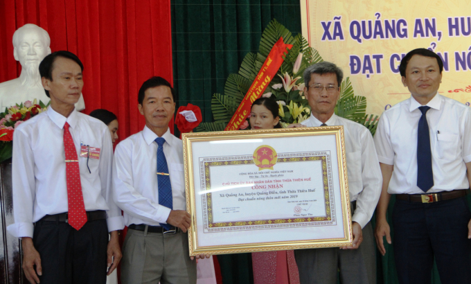 Ông Hồ Vang, Phó Giám đốc Sở NN - PTNT tỉnh Thừa Thiên- Huế (bìa phải) trao bằng công nhận xã đạt chuẩn NTM cho lãnh đạo xã Quảng An. Ảnh: Tiến Thành.