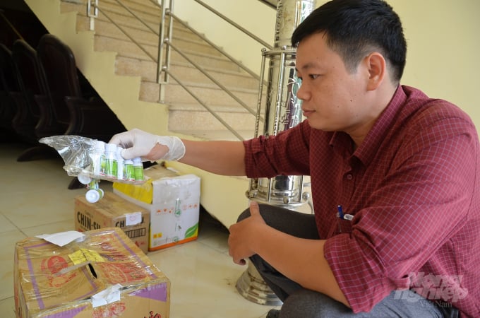 Ông Bùi Mạnh Tiến - Trạm trưởng Trạm Trồng trọt và BVTV Mê Linh đang xem lô hàng thuốc lậu vừa bắt được. Ảnh: Dương Đình Tường.