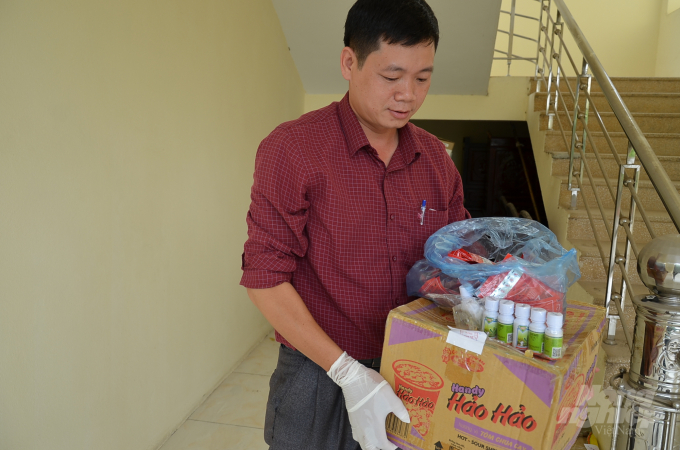 Ông Bùi Mạnh Tiến - Trạm trưởng Trạm Trồng trọt và BVTV Mê Linh với số tang vật thuốc lậu thu được ở cửa hàng của đại lý Nguyễn Văn Thuần. Ảnh: Dương Đình Tường.