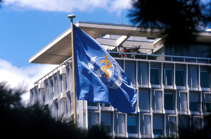 Lá cờ mang logo của WHO tung bay bên ngoài trụ sở chính tại Geneva. Ảnh: WHO.