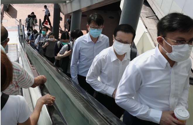 Người dân Hong Kong đeo khẩu trang đi làm. Ảnh: SCMP.