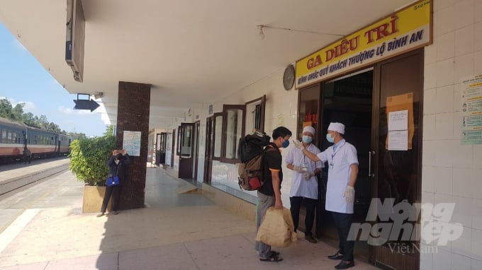 Hành khách đi từ Đà Nẵng về ga Diêu Trì được đo thân nhiệt trước cửa vào nhà chờ. Ảnh: Vũ Đình Thung.