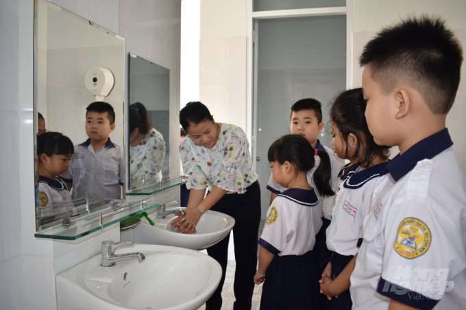 Ngày đầu đến trường, học sinh lớp 1 được giáo viên hướng dẫn cách rửa tay, cách sử dụng nhà vệ sinh. Ảnh: Thùy Lâm.