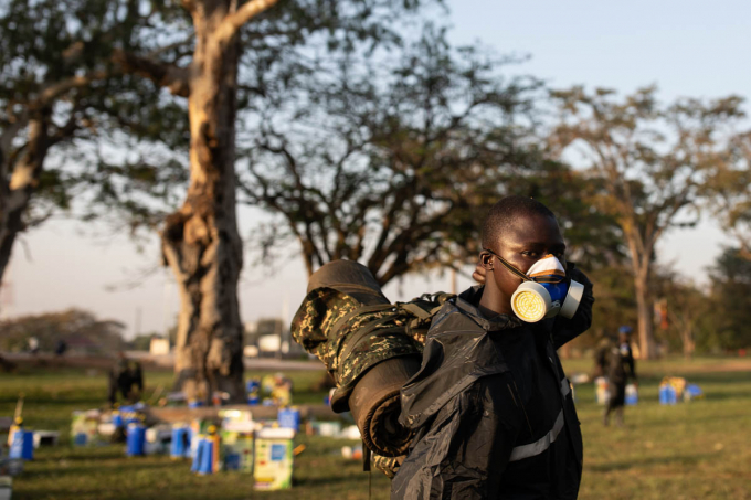 Binh sĩ Uganda đeo mặt nạ để phun thuốc trừ sâu, diệt châu chấu. Ảnh: Atlantic.
