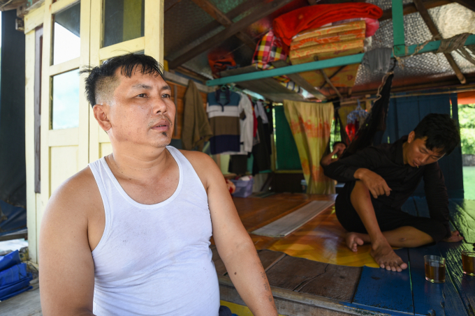 Anh Nguyễn Văn Dương (áo trắng), chủ nhà bè ở Cửa Vạn với hơn 10 lồng nuôi cá song, cá vược đang kể chuyện về những thay đổi trong cuộc sống của gia đình sau khi chuyển từ đánh bắt sang nuôi trồng. Ảnh: Tùng Đinh.
