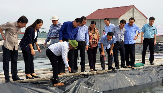 Bộ trưởng Bộ NN-PTNT Nguyễn Xuân Cường (thứ tư từ trái qua) thăm mô hình thủy sản tại huyện Kim Sơn, tỉnh Ninh Bình. Ảnh: Lê Tuấn.