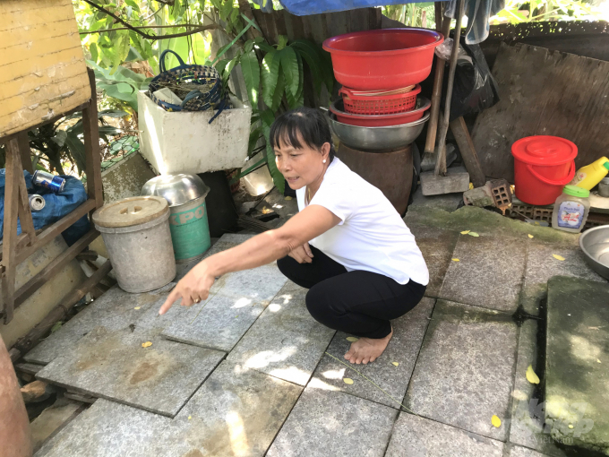 Bà Phan Thị Kim Thoa chỉ công trình phụ của gia đình xây dựng dưới lòng đất từ năm 1993, trên phần đất mà giờ bị buộc phải giao cho bà Hằng. Ảnh: Vũ Đình Thung.