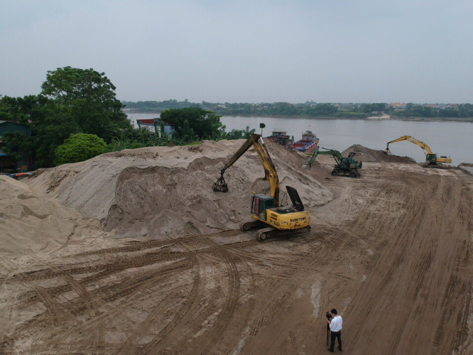 Bãi tập kết của Công ty TNHH Thắng Mạnh Cường vẫn đang hoạt động trong mùa mưa bão, thậm chí những đống cát nằm sát bờ sông Hồng. Ảnh: Minh Phúc.