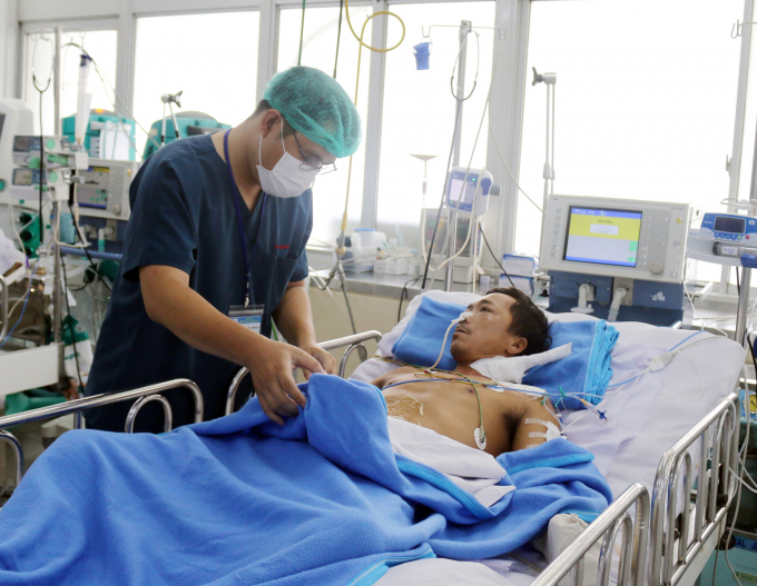 Bác sĩ Nguyễn Lý Minh Duy, khoa Hồi sức Cấp cứu Bệnh viện Chợ Rẫy đang điều trị cho bệnh nhân Phan Văn Tâm. Ảnh: Bệnh viện cung cấp.