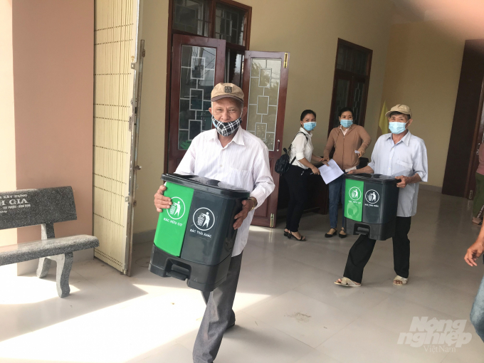 Những người dân xã Phước Lộc trực tiếp tham dự lễ đăng ký tham gia phân loại rác thải tại nguồn hồ hởi nhận thùng đựng rác. Ảnh: Vũ Đình Thung.