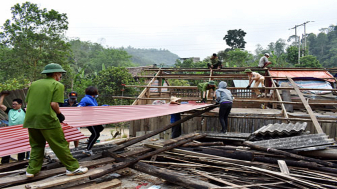 Cán bộ tại huyện Pác Nặm giúp đỡ nhân dân sửa lại mái nhà dân bị hư hỏng do mưa đá. Ảnh: Văn Lạ.