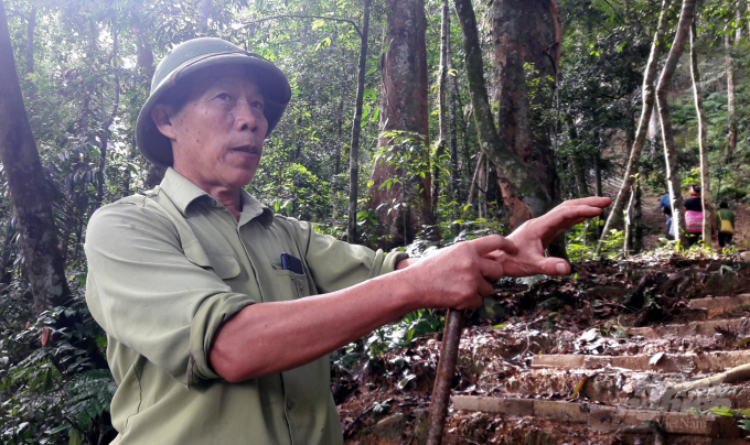 Trưởng bản Lang Hồng Tuyên kể về một lần bị rắn độc tấn công trên đường tuần tra rừng bản Vịn. Ảnh: Võ Dũng.