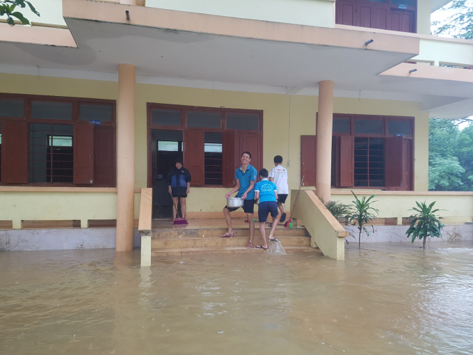 Thầy cô lấm lem bùn đất nhưng vẫn tươi cười vui vẻ khi dọn dẹp vệ sinh lớp học. Ảnh: M.Tuấn.