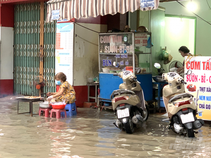 Tại đường Trần Hưng Đạo - TP Cần Thơ, một số cửa hàng mua bán, sinh hoạt của người dân gặp khó khăn do ngập lụt. Ảnh: HĐ.