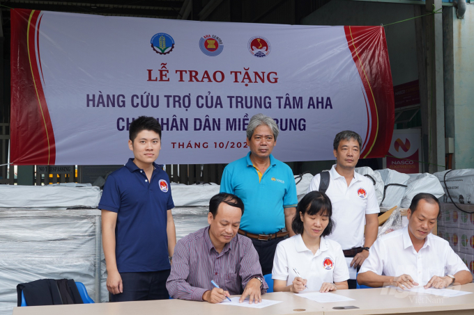 Đại diện tỉnh Thừa Thiên - Huế và Quảng Trị ký nhận bàn giao số hàng viện trợ. Ảnh: TT.