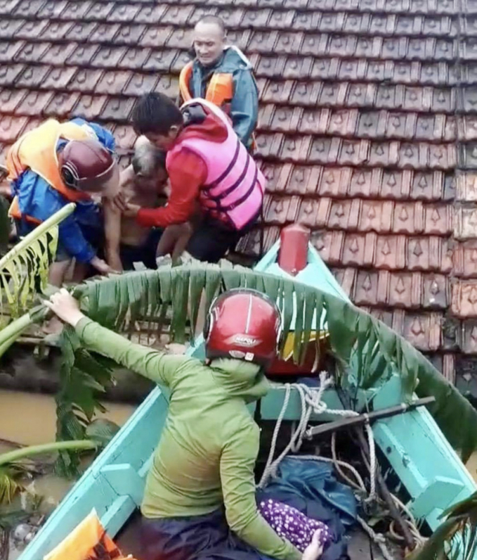 Ngư dân cứu hộ bà con vùng lũ đang mắc kẹt trên mái nhà. Ảnh: N. Dương