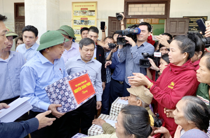Thủ tướng Nguyễn Xuân Phúc tặng quà và thăm hỏi người dân xã Hiền Ninh. Ảnh: T.Phùng.