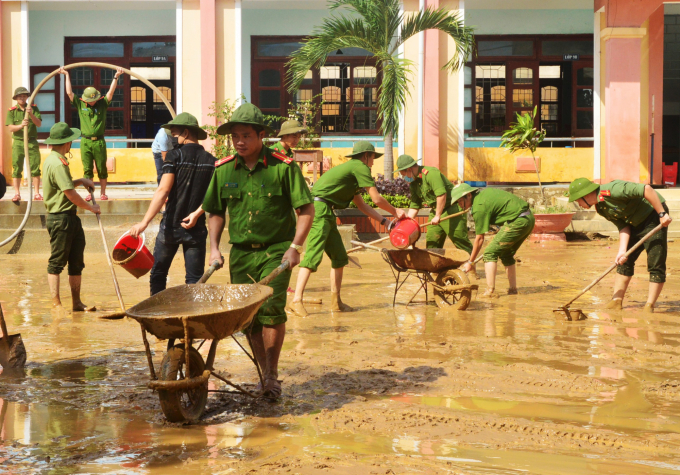 Lực lượng công an Quảng Bình hỗ trợ làm vệ sinh môi trường. Ảnh: A.T.