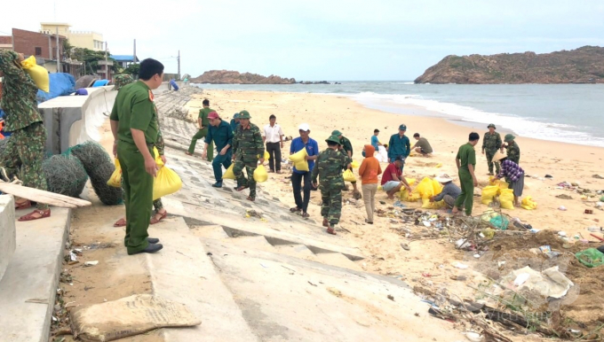 Lực lượng vũ trang giúp dân xã biển Nhơn Hải (TP Quy Nhơn, Bình Định) xúc cát giằng chống nhà cửa ứng phó bão số 9. Ảnh: Vũ Đình Thung.
