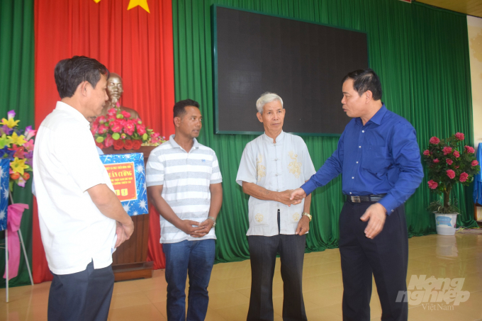 Bộ trưởng Bộ NN-PTNT Nguyễn Xuân Cường an ủi và trao quà cho đại diện 2 gia đình có tàu chìm trong bão số 9. Ảnh: Vũ Đình Thung.