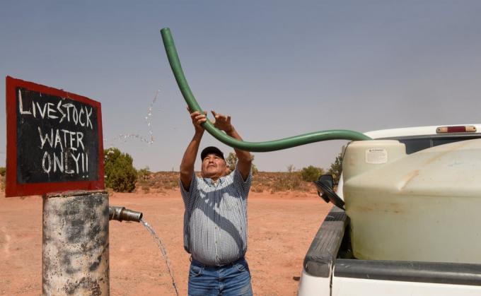 Một nông dân chăn nuôi ở Arizona đổ đầy bể nước cho gia súc của mình uống. Ảnh: Reuters.