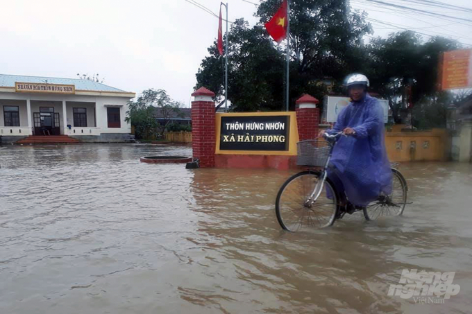 Người dân di chuyển trên tuyến đường ngập lụt ở huyện Hải Lăng chiều 11/11. Ảnh: CĐ.