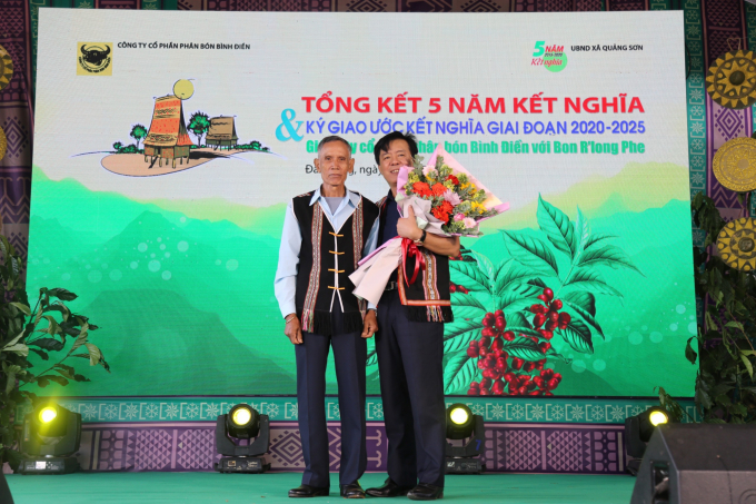   Ông Ngô Văn Đông, Tổng giám đốc Phân bón Bình Điền nhận bó hoa tươi thắm từ đại diện bon R’long Phe. Ảnh: Đình Thế.