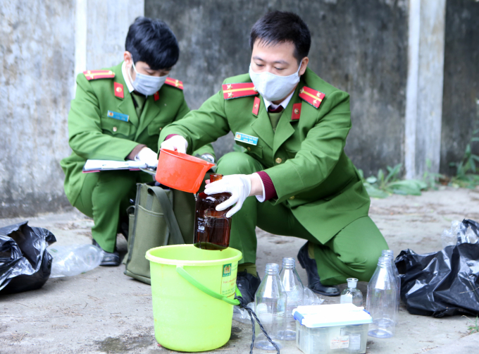Cán bộ C05 lấy mẫu nước tại hố ga hệ thống nước thải của Bệnh viện Đa khoa tỉnh Hải Dương để mang đi phân tích, kiểm định chất lượng. Ảnh: Minh Phúc.
