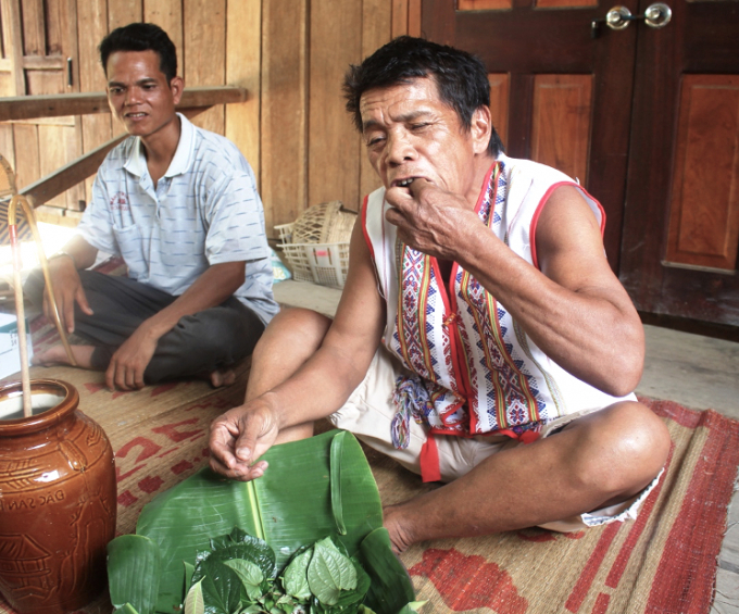 Già làng A Blong (phải), thử trước món gỏi cá kiến vàng trước khi mời khách. Ảnh: Phúc Lập.