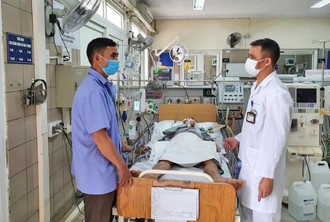Bác sĩ Nguyễn Trung Nguyên thăm khám bệnh nhân ngộ độc rượu. Ảnh: Tiền Phong.