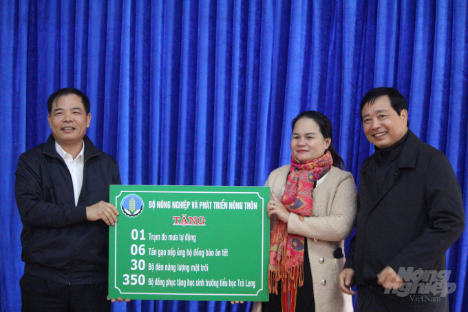Ông Nguyễn Xuân Cường, Bộ trưởng Bộ NN-PTNT trao quà hỗ trợ cho người dân Trà Leng. Ảnh: L.K. 
