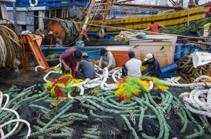 Các ngư dân tranh thủ phối màu vào lưới để ra khơi trong năm mới