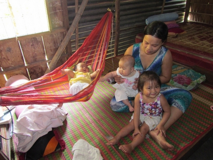 Chị Trần Minh Tuyết đang trông mấy đứa trẻ con công nhân trong nhóm trong căn nhà gỗ tạm bợ. Ảnh: Phúc Lập.