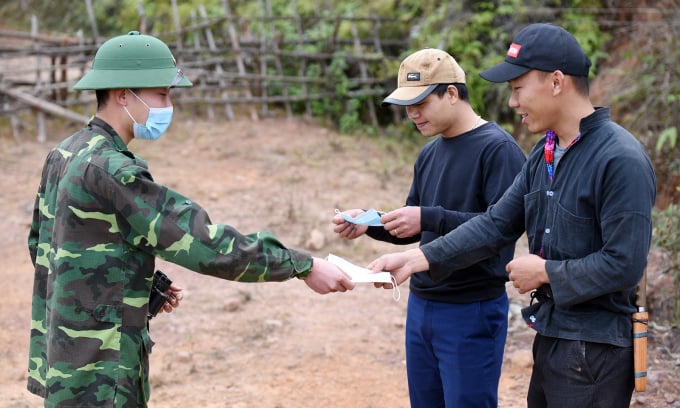 Chiến sĩ Đồn Si Pa Phìn phát khẩu trang cho người dân trong lúc tuần tra. Ảnh: Bảo Thắng.