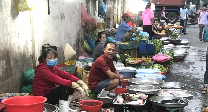 Chị Hoàng Thị Thái (bìa trái), đang tập bán cá đợi công ty gọi đi làm trở lại. Ảnh: Phúc Lập.