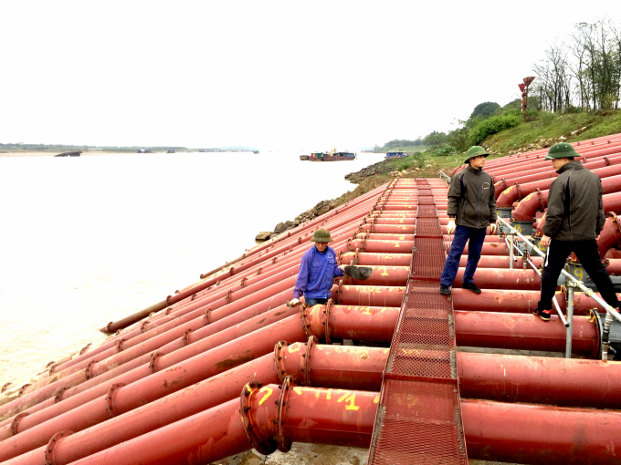 Công nhân trạm bơm dã chiến Phù Sa (Thị xã Sơn Tây, Hà Nội) kiểm tra an toàn trong quá trình vận hành các tổ máy bơm lấy nước từ sông Hồng. Ảnh: Minh Phúc.