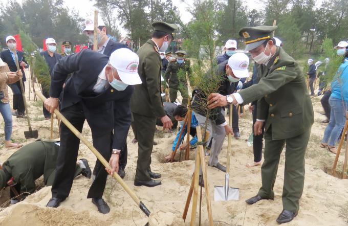 Thứ trưởng thường trực Hà Công Tuấn (trái) trồng cây tại bờ biển Quảng Bình. Ảnh: N.Tâm