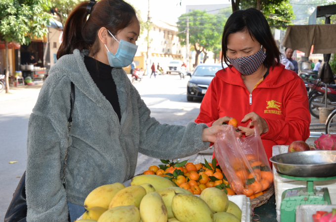 Cảnh mua bán hoa quả ngoài đường ở phường Minh Khai, TP Phủ Lý. Ảnh: Dương Đình Tường.