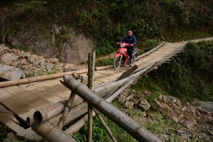 Con đường vào thôn Đề Chơ phải qua cây cầu bằng gỗ bung biêng như thế này. Ảnh: Thái Sinh. 