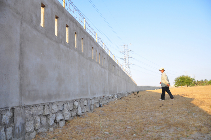 Tường bê tông bao quanh hồ cao 2-3m khiến cho gia súc của người dân không thể vào hồ uống nước. Ảnh: M.H.