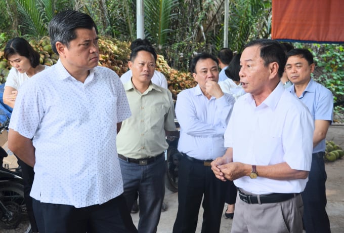 Thứ trưởng Trần Thanh Nam (trái) trao đổi với ông Phạm Quang Đằng (phải) về tình hình sản xuất, tiêu thụ dừa hữu cơ tại HTX Châu Hoà. Ảnh: Minh Đảm.