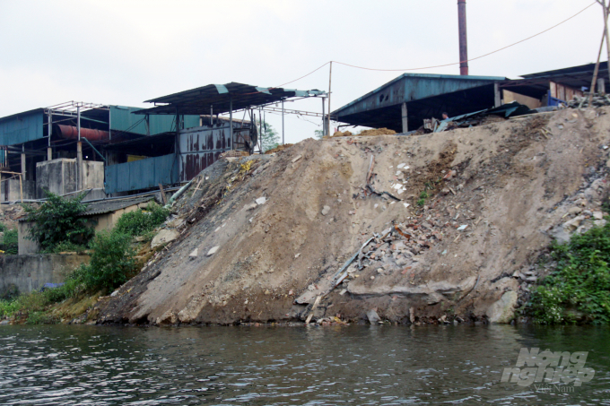 Các cơ sở chế biến tre luồng trên địa bàn xã Phú Nghiêm (Quan Hóa) đổ chất thải xây dựng, chất thải sản xuất ra sông Mã. Ảnh: Võ Dũng.