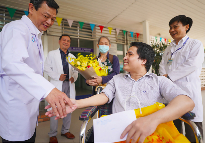 Bác sĩ Nguyễn Tri Thức, Giám đốc Bệnh viện Chợ Rẫy chúc mừng hai mẹ con Phan Hữu Nghiêm ngày xuất viện.