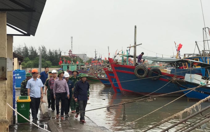 Ông Phạm Văn Thép (áo trắng), kiểm tra công tác phòng chống thiên tai trước khi bão đổ bộ tại cảng cá Ngọc Hải. Ảnh: Đinh Mười.